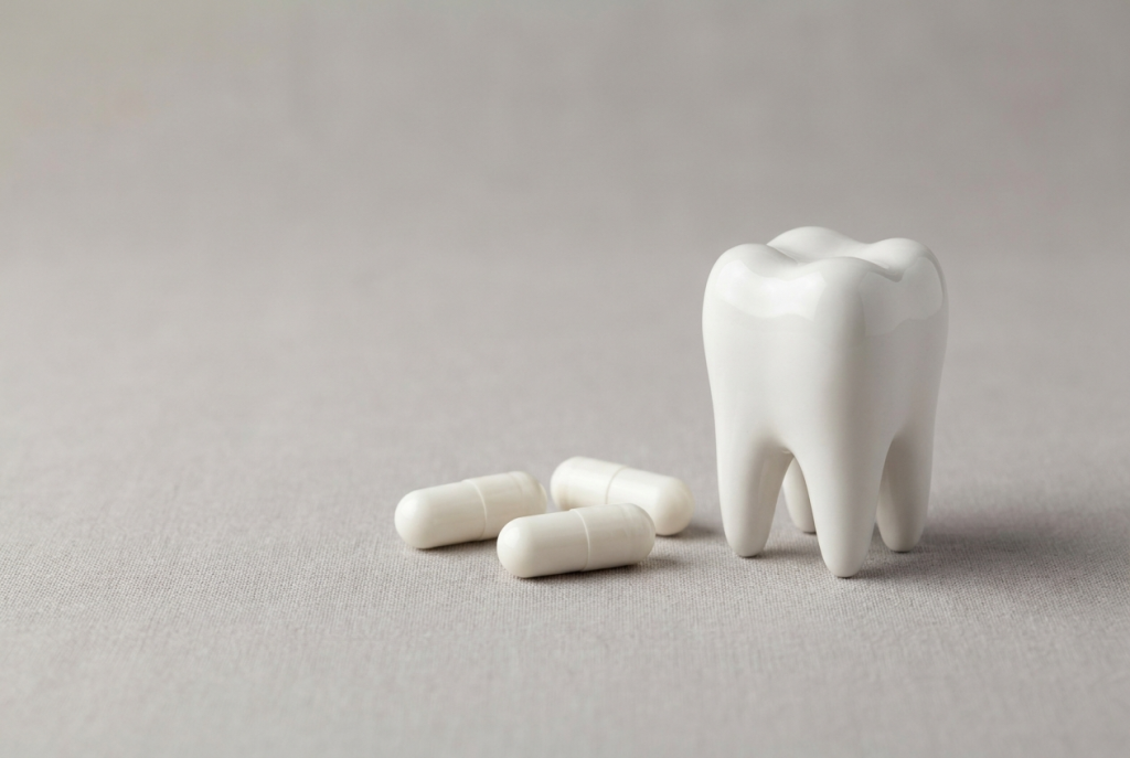 Antibiotic capsules beside a tooth model at Total Care Dental